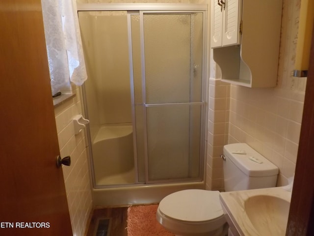 bathroom featuring hardwood / wood-style floors, sink, toilet, tile walls, and an enclosed shower