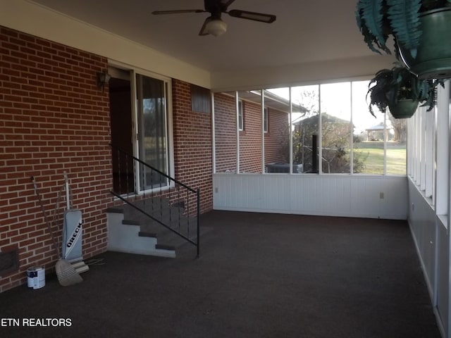 unfurnished sunroom with ceiling fan