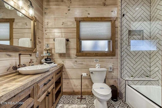 full bathroom featuring enclosed tub / shower combo, wooden walls, tile patterned floors, toilet, and vanity