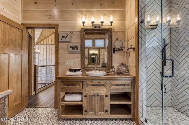 bathroom featuring a shower with door, vanity, and wood walls