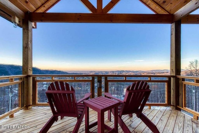 deck at dusk featuring a mountain view