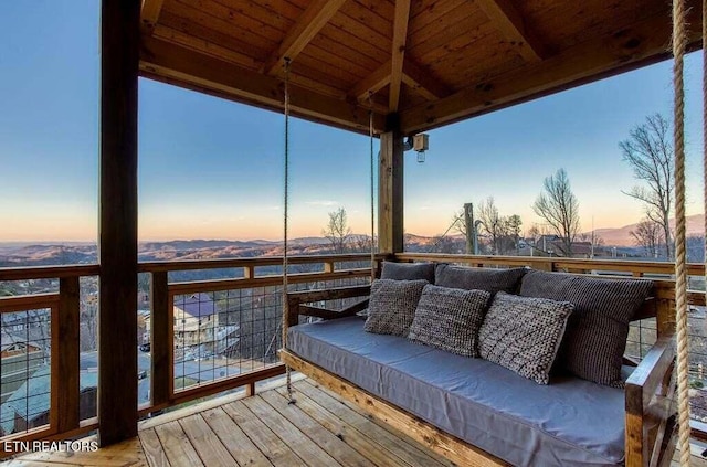 deck at dusk with a mountain view and outdoor lounge area