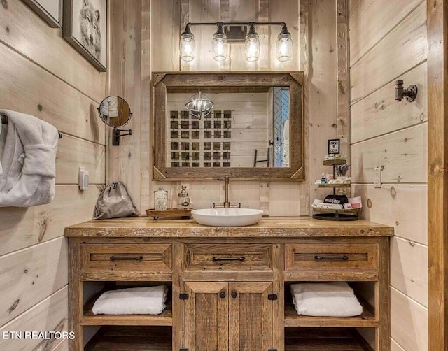 bathroom with vanity and wood walls