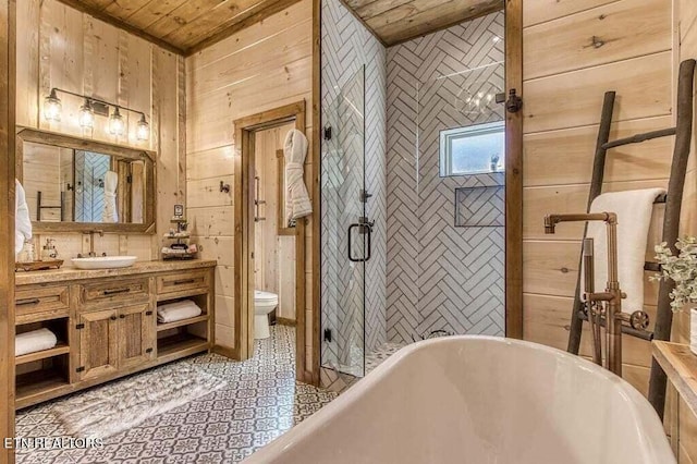 bathroom with vanity, toilet, a bathing tub, and wooden walls