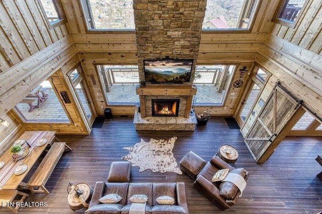 unfurnished living room featuring plenty of natural light, a towering ceiling, and dark hardwood / wood-style floors