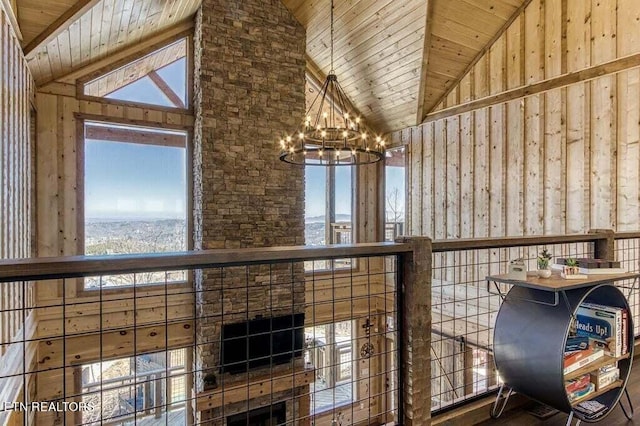 interior space featuring wood ceiling, high vaulted ceiling, a wealth of natural light, and an inviting chandelier