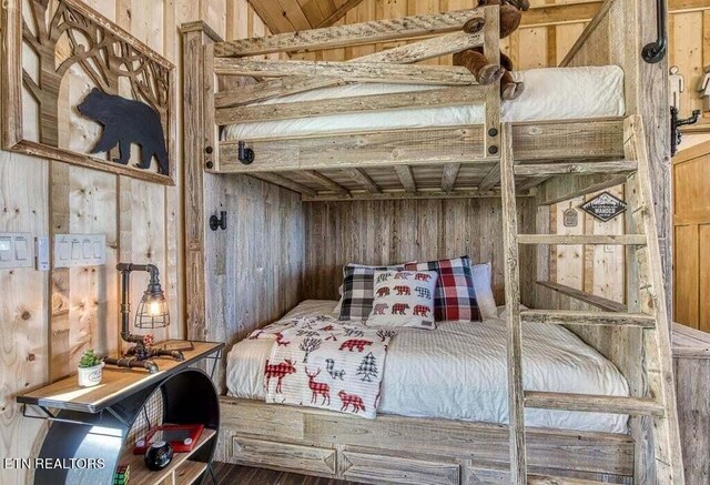 bedroom featuring wood walls and wood-type flooring