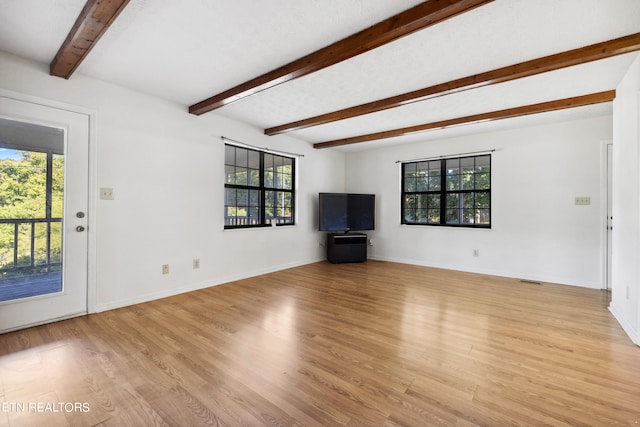 unfurnished living room with light hardwood / wood-style flooring and beamed ceiling