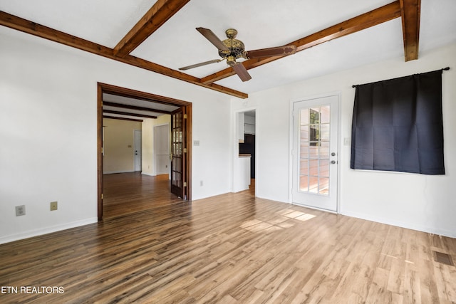 empty room featuring ceiling fan, wood-type flooring, and beam ceiling