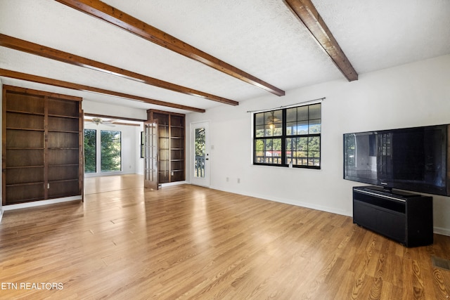 unfurnished living room with a textured ceiling, plenty of natural light, light hardwood / wood-style flooring, and ceiling fan