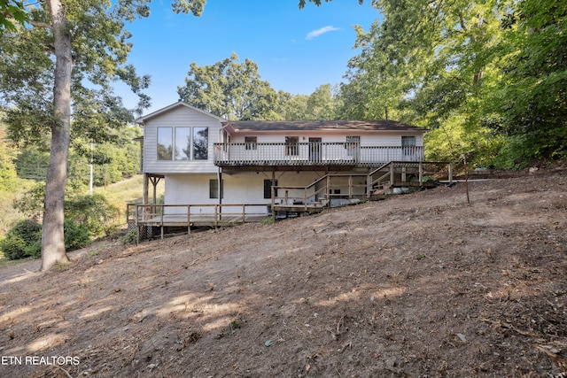 rear view of house featuring a wooden deck