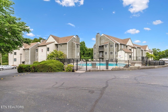 view of front of home with a fenced in pool