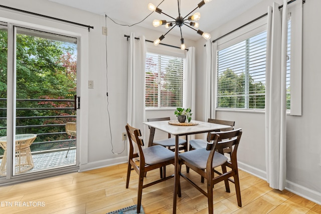 dining space featuring light wood-type flooring, a chandelier, and a wealth of natural light