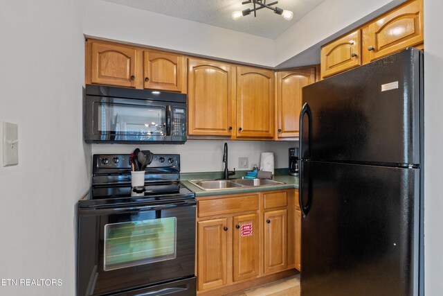 kitchen with black appliances, a textured ceiling, and sink