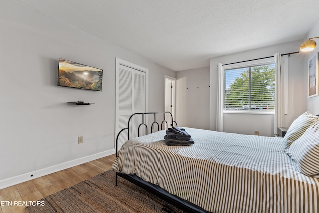 bedroom with a textured ceiling and hardwood / wood-style flooring