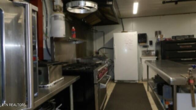 kitchen with white fridge and stainless steel gas range