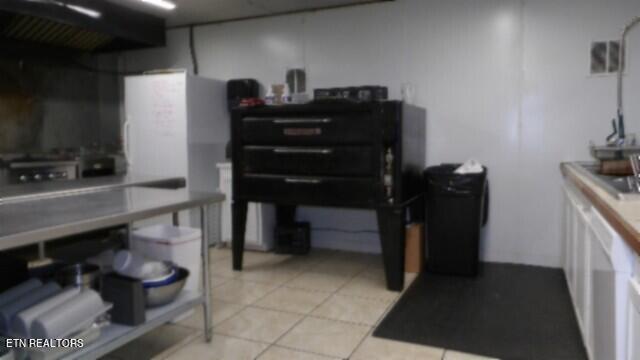 kitchen with ventilation hood and light tile patterned flooring