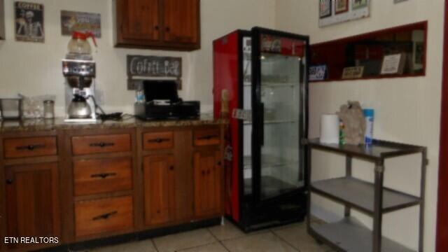 kitchen with black fridge and light tile patterned floors