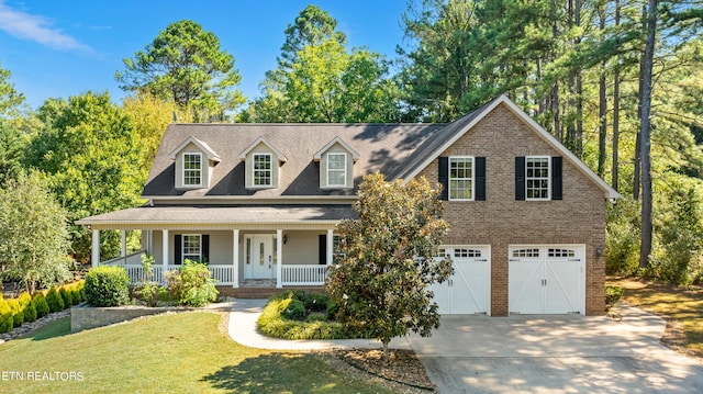 view of front of property featuring a front lawn, a garage, and a porch