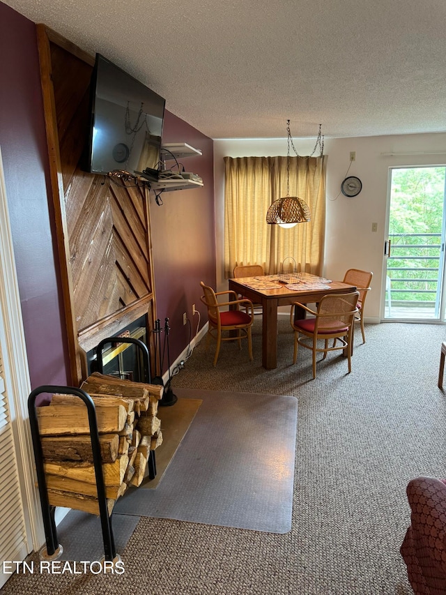 dining room featuring a textured ceiling, carpet flooring, and a fireplace