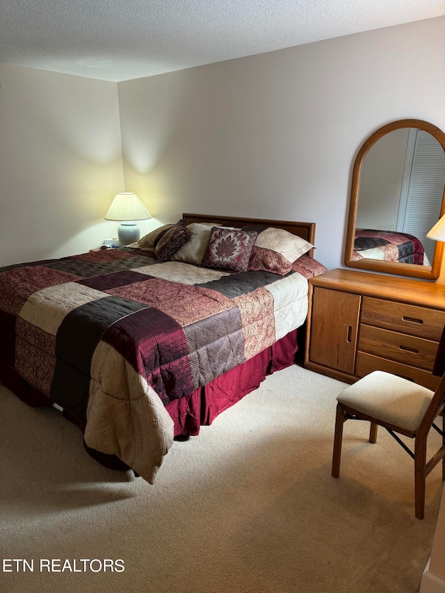 bedroom featuring carpet and a textured ceiling