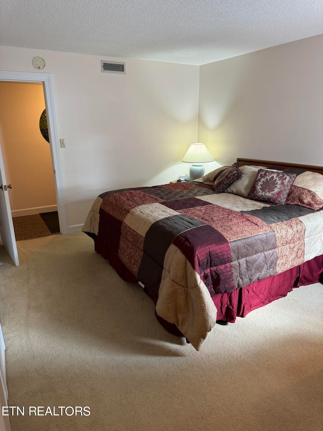 bedroom featuring a textured ceiling and carpet