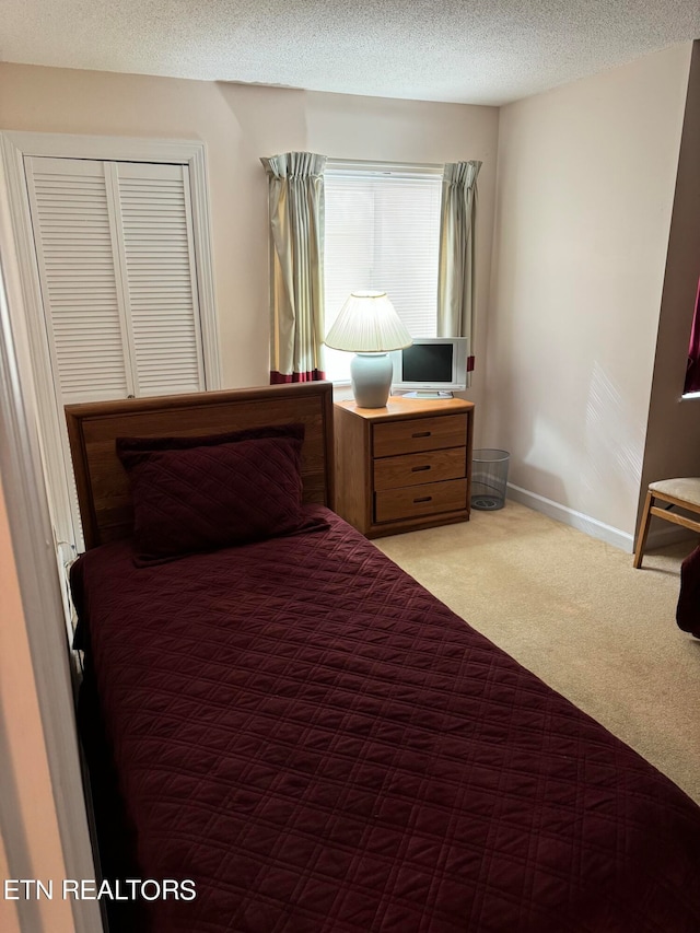 bedroom with a textured ceiling and light carpet