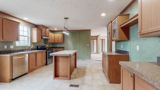 kitchen with a textured ceiling, a kitchen island, decorative light fixtures, crown molding, and stainless steel appliances