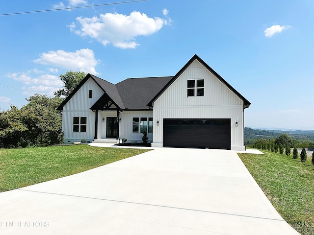 modern farmhouse with a garage, driveway, roof with shingles, board and batten siding, and a front yard