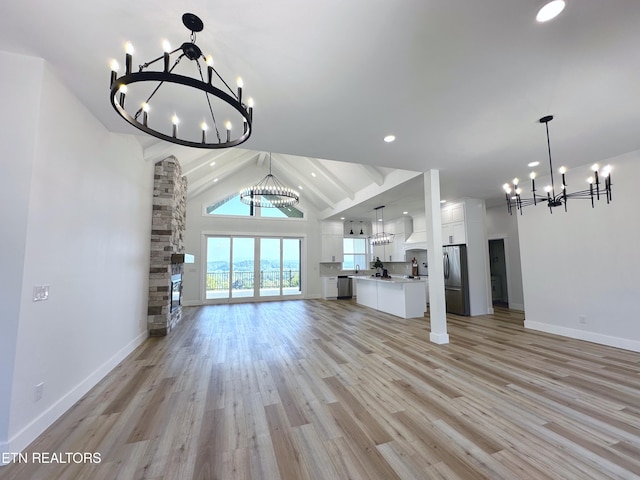 unfurnished living room with a chandelier, high vaulted ceiling, recessed lighting, baseboards, and light wood-type flooring