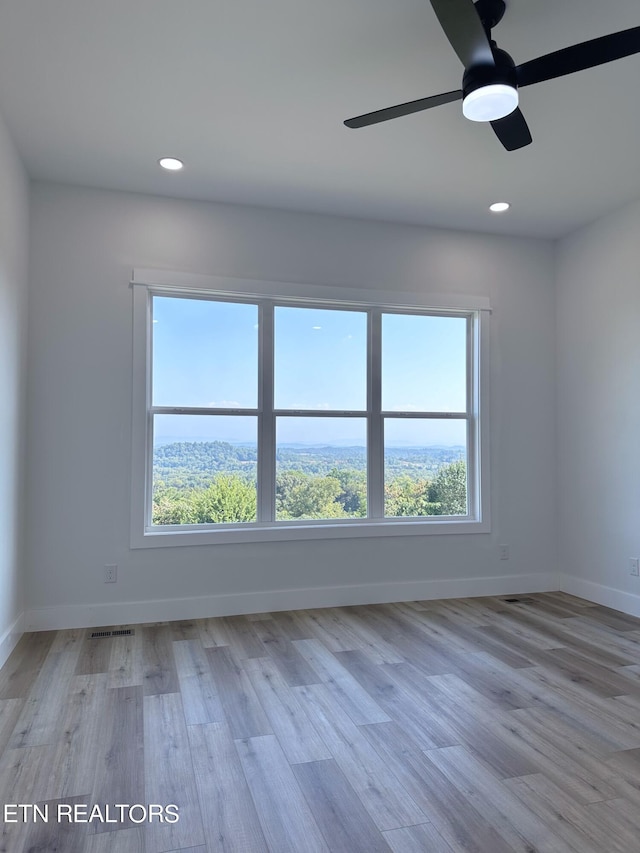 empty room with recessed lighting, visible vents, baseboards, and wood finished floors