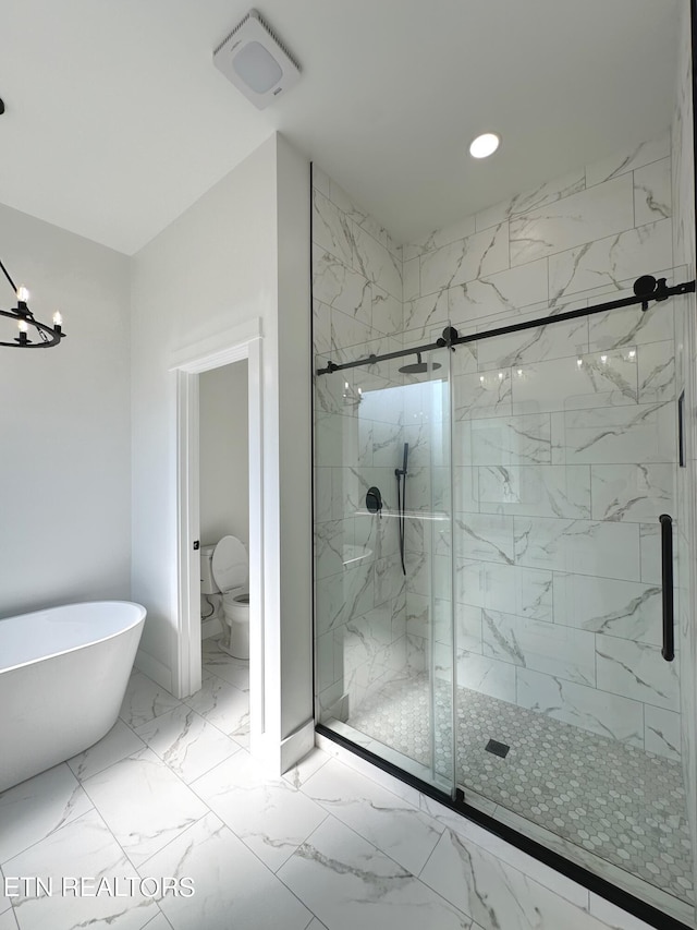 bathroom with a marble finish shower, marble finish floor, a freestanding bath, and toilet