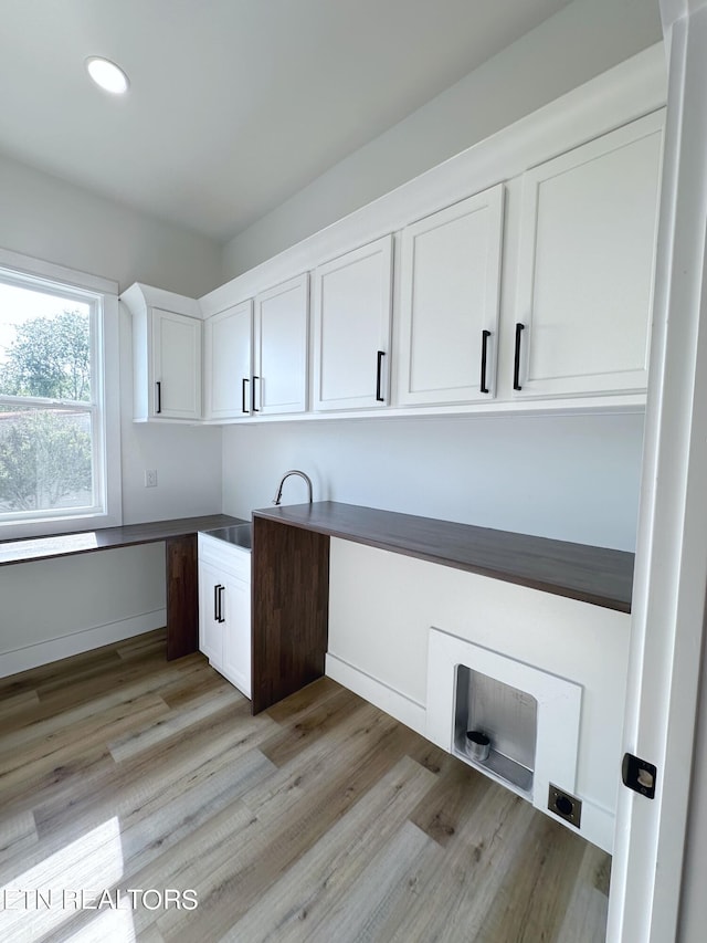 interior space with cabinet space, light wood-style flooring, baseboards, and recessed lighting