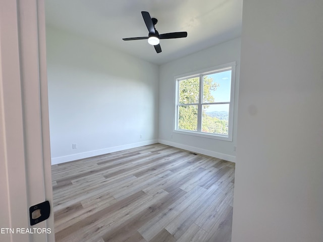 spare room with ceiling fan, wood finished floors, and baseboards