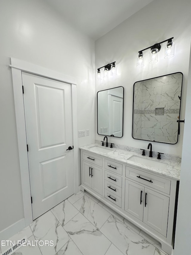 full bath featuring marble finish floor, walk in shower, a sink, and double vanity