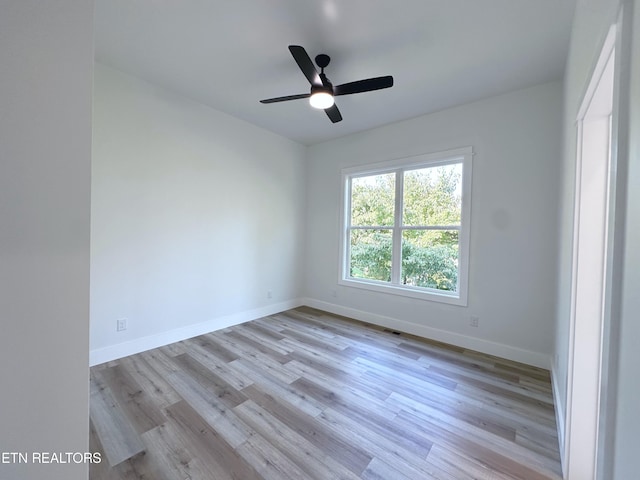 empty room featuring light wood-style floors, visible vents, ceiling fan, and baseboards