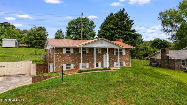 view of front facade with a front yard, a storage shed, and central air condition unit