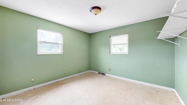 unfurnished room featuring a textured ceiling and concrete flooring