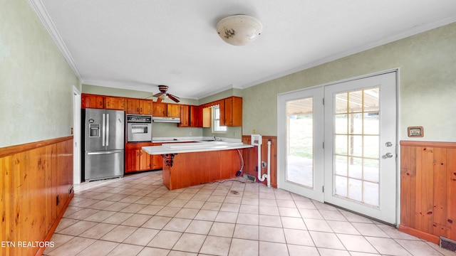 kitchen featuring oven, stainless steel fridge, crown molding, kitchen peninsula, and ceiling fan