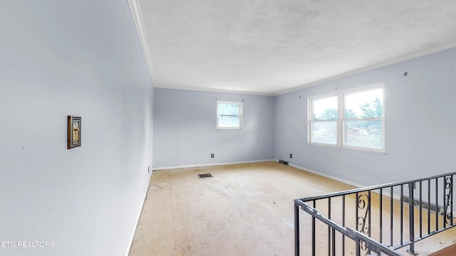 unfurnished room with a textured ceiling and ornamental molding