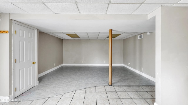 basement with light tile patterned floors and a drop ceiling