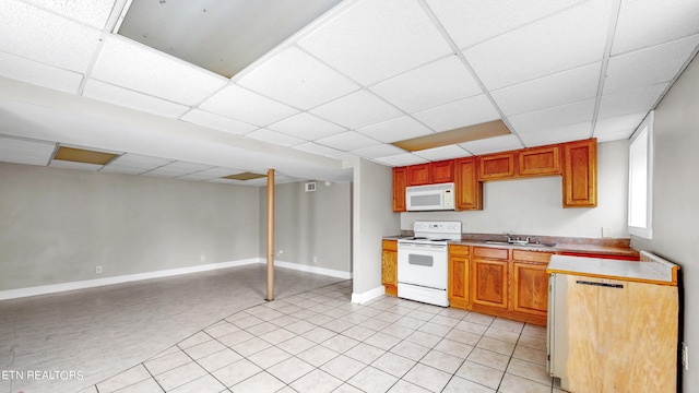 kitchen featuring white appliances, light tile patterned floors, a drop ceiling, and sink