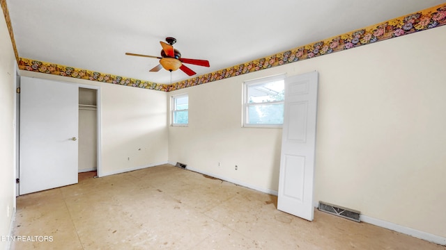 unfurnished bedroom with ceiling fan and a closet