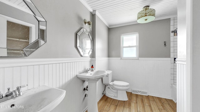 full bathroom featuring separate shower and tub, hardwood / wood-style floors, toilet, sink, and ornamental molding