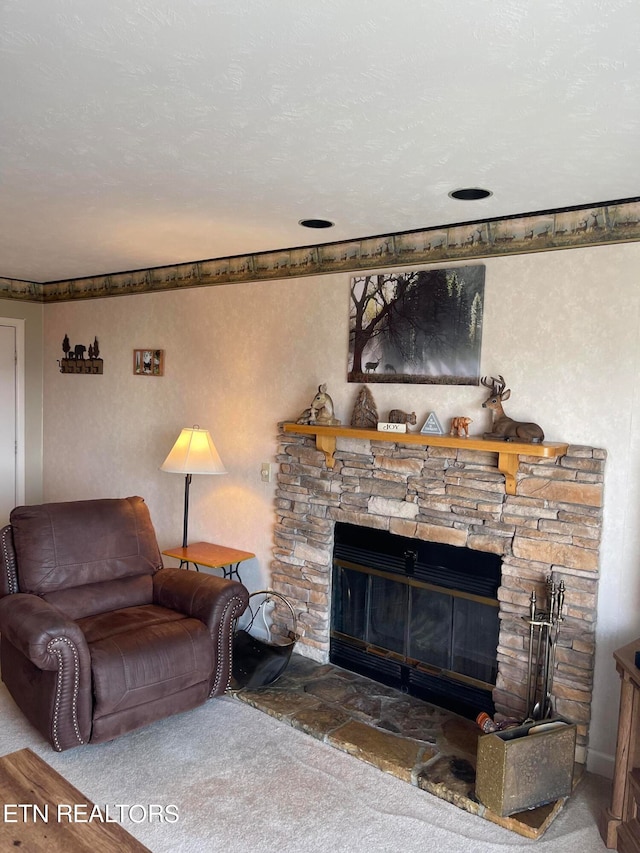 carpeted living room featuring a textured ceiling and a stone fireplace