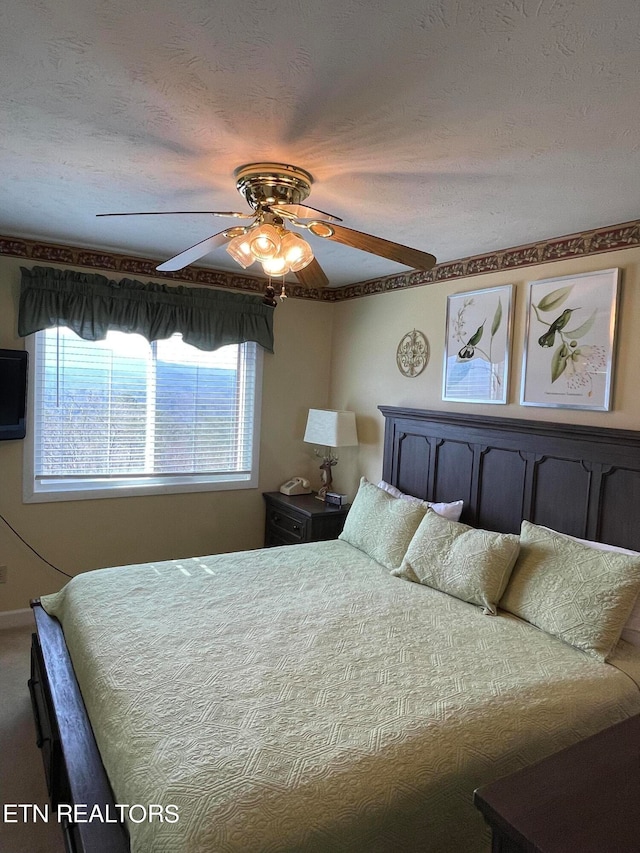 bedroom with a textured ceiling, ceiling fan, and carpet floors