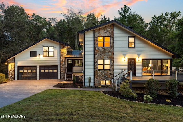 view of front of home with a garage, a wooden deck, and a yard