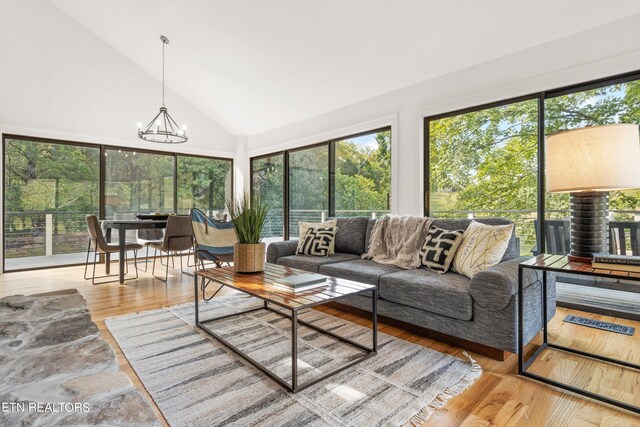 sunroom featuring lofted ceiling, a wealth of natural light, and a chandelier