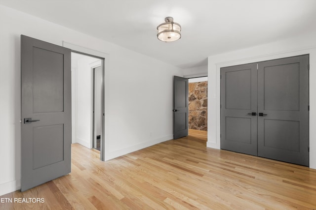 unfurnished bedroom featuring light hardwood / wood-style flooring and a closet