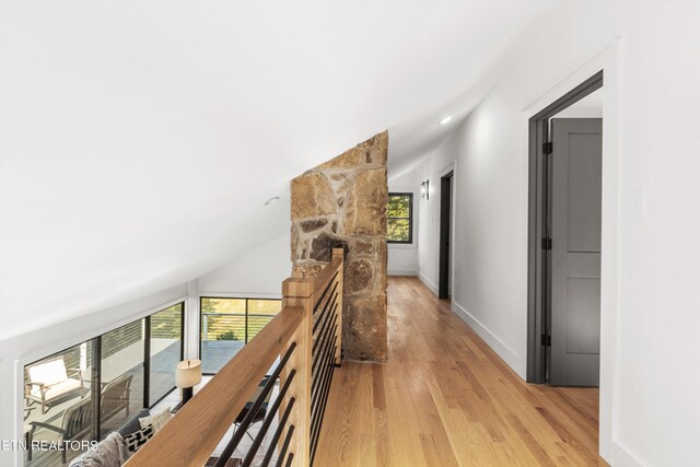 corridor featuring vaulted ceiling and light hardwood / wood-style floors